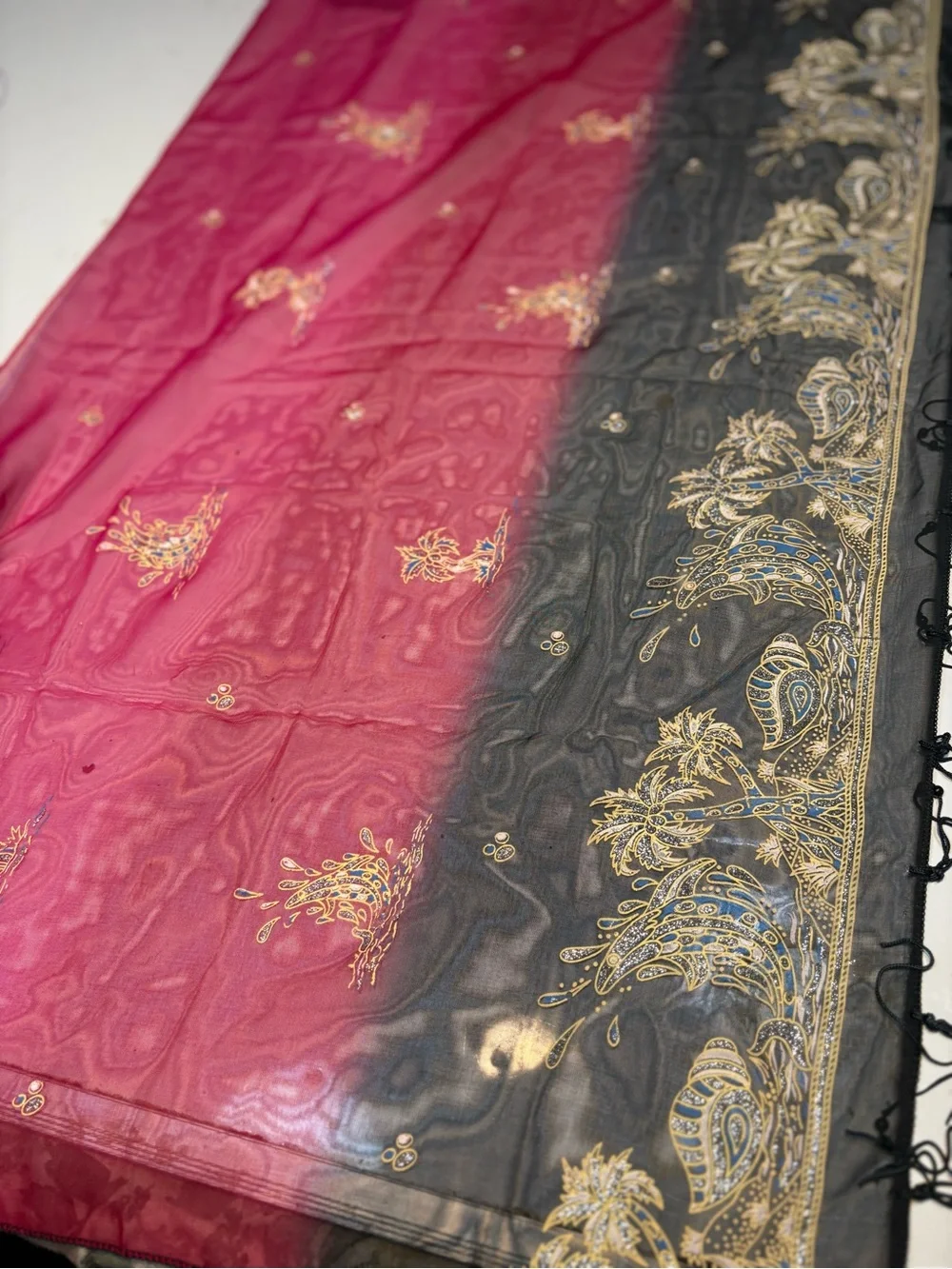 magenta and black scarf features palm tree motifs and black tassels along the ed